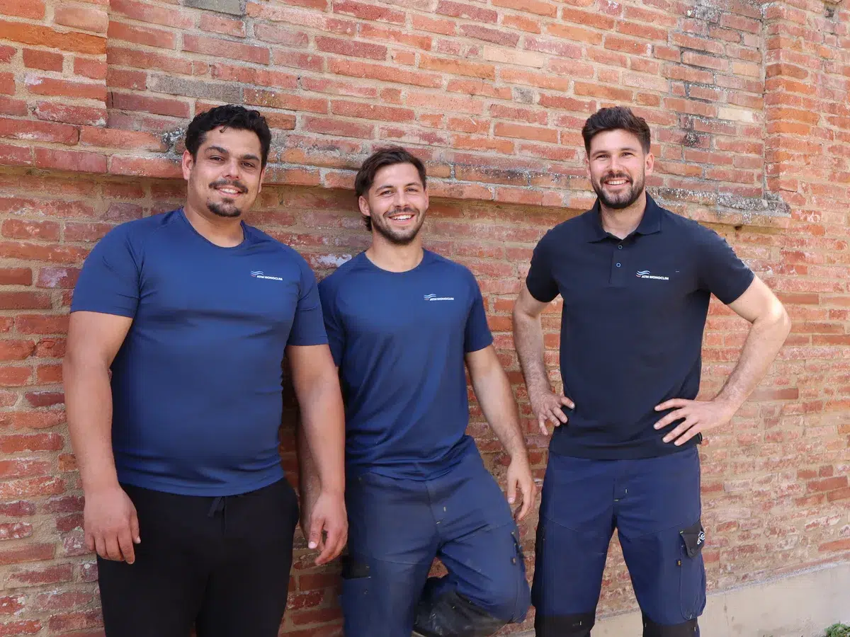 Yvan, Lenny et Mathieu, l’équipe ATM Monoclim, devant un mur en brique à Toulouse